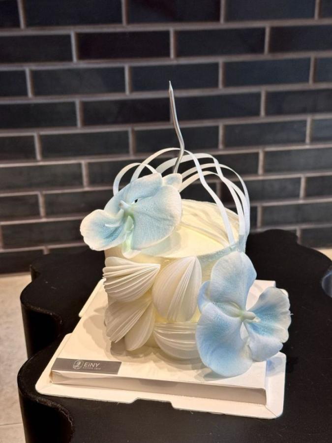 Textured cake with pale blue blooms and silver ribbon loops