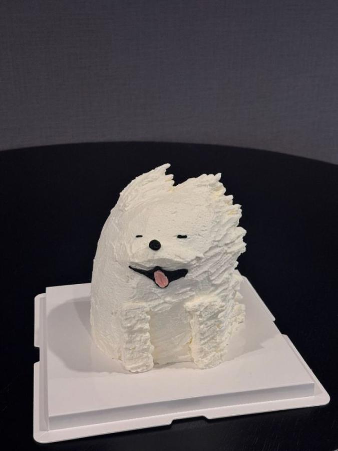 Fluffy white puppy cake with a pink tongue