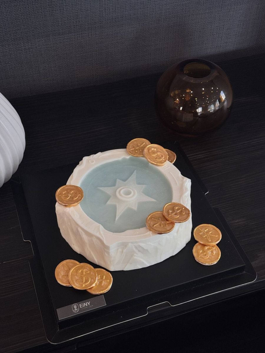 Celadon wishing well cake with gilded coins scattered around it